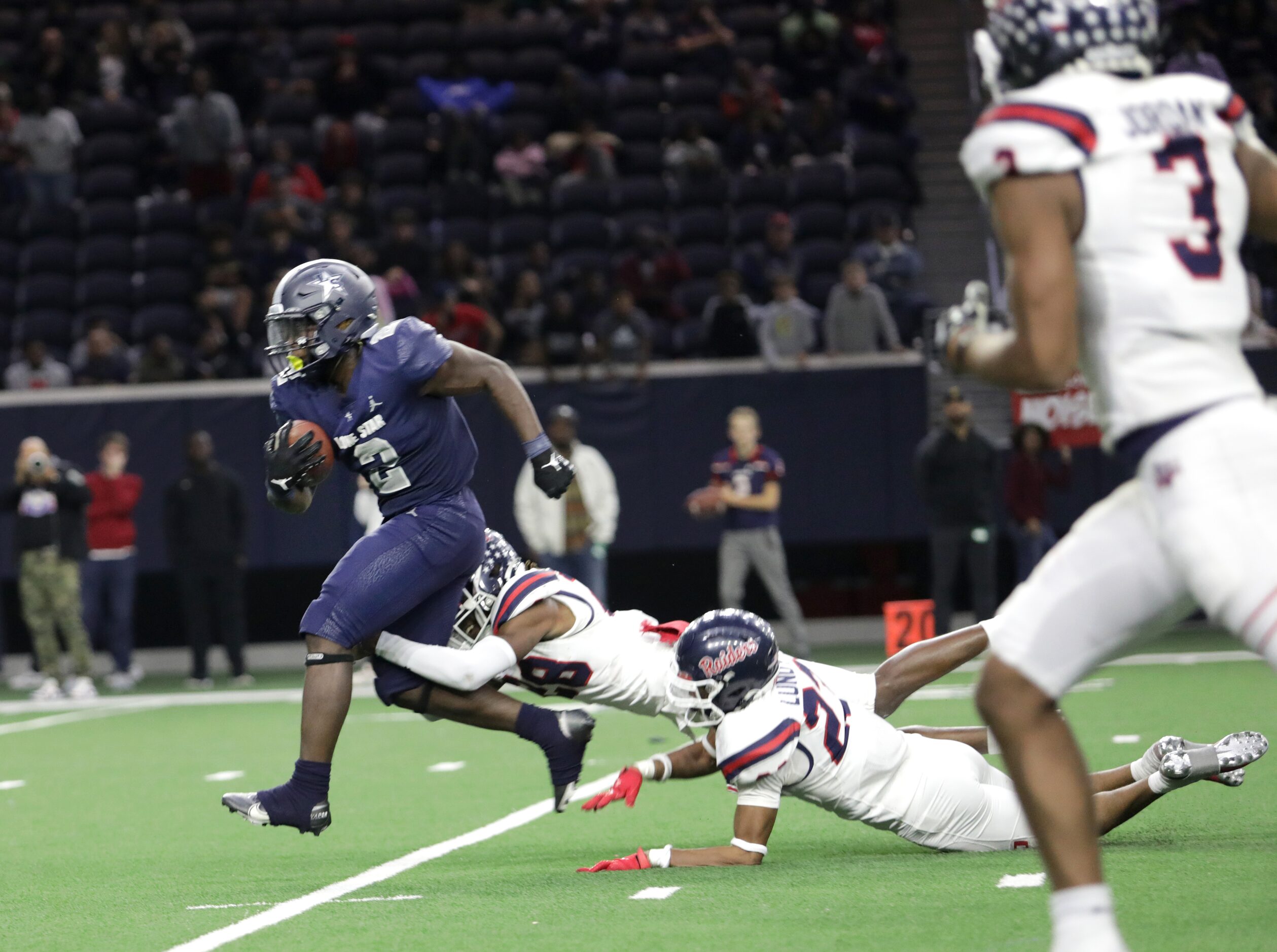 Lone Star player #2, Ashton Jeanty, tries to break a tackle by Ryan player #28, Kaden Kelly,...