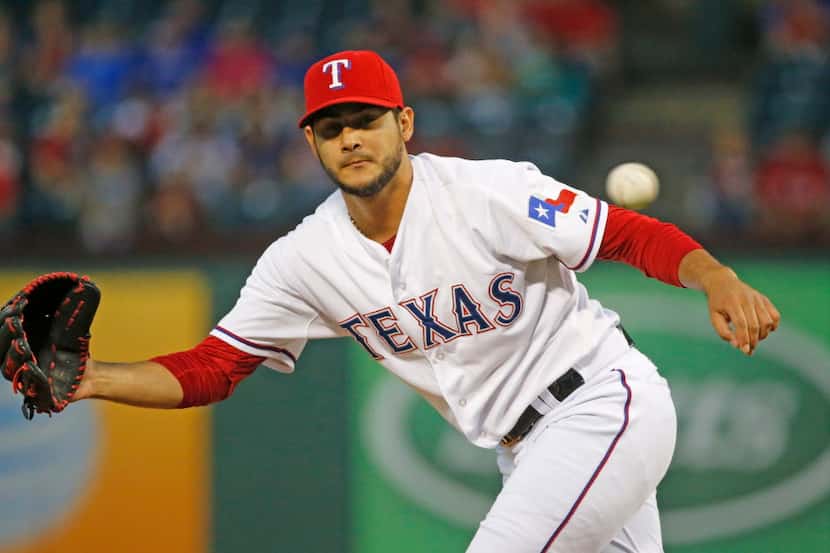 Texas Rangers starting pitcher Martin Perez (33) tries to glove Los Angeles Angels shortstop...