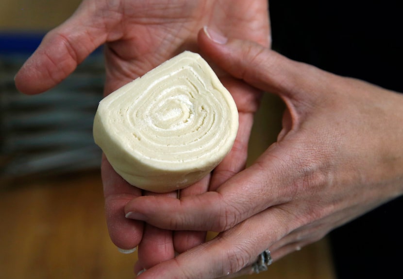 Detail of an uncooked kouign-amann held by Andrea Meyer