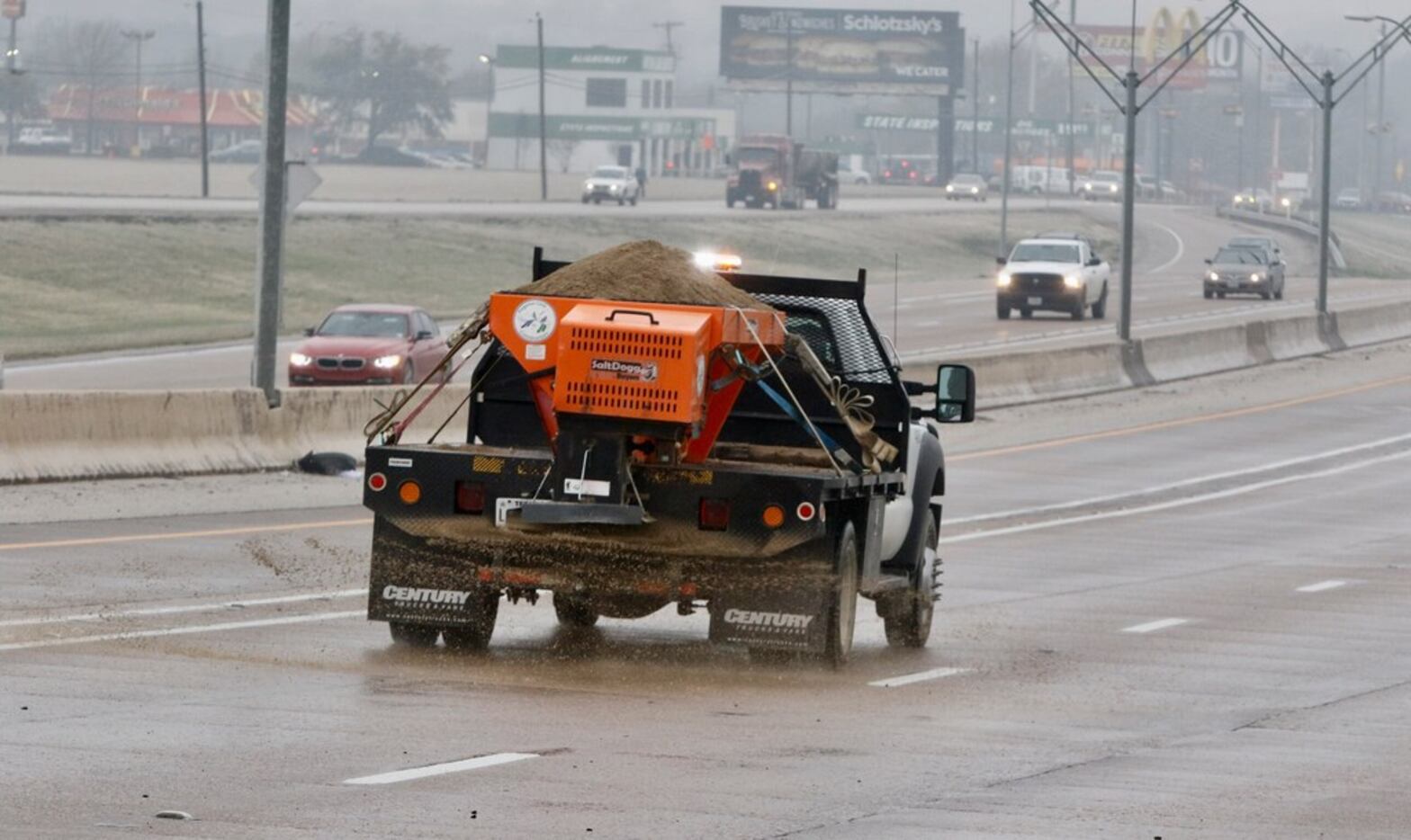 A sand truck spreads sand on southbound Hwy. 67 near the Red Bird Lane exit on February 28,...