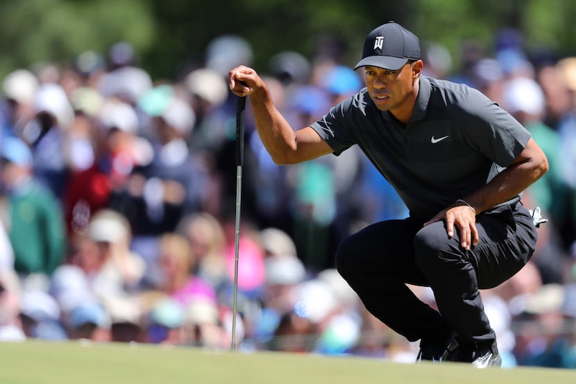 Tiger Woods lines up his putt on the 7th green during the first round of the Masters at...