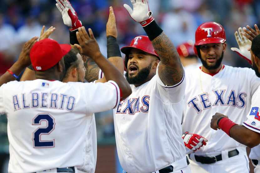 Texas Rangers designated hitter Prince Fielder (center is congratulated by his teammates...