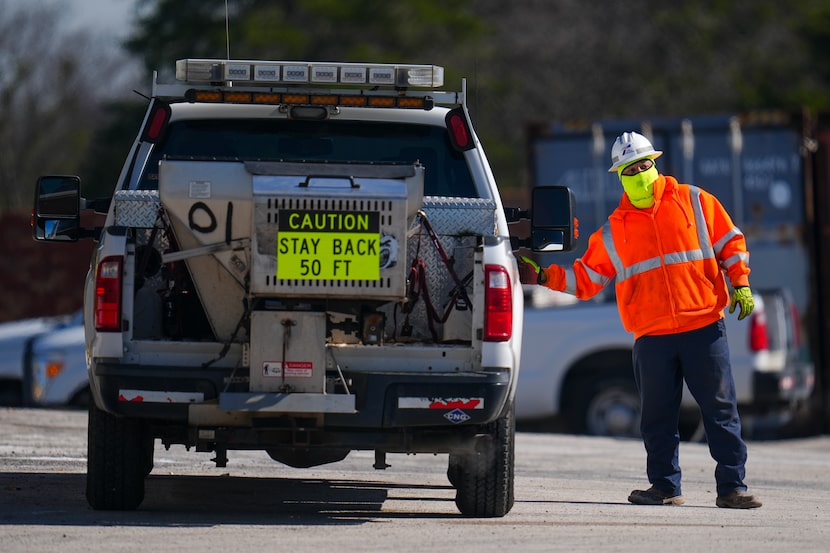 A worker is bundled up in near-freezing temperatures as he loads into a salt spreading truck...