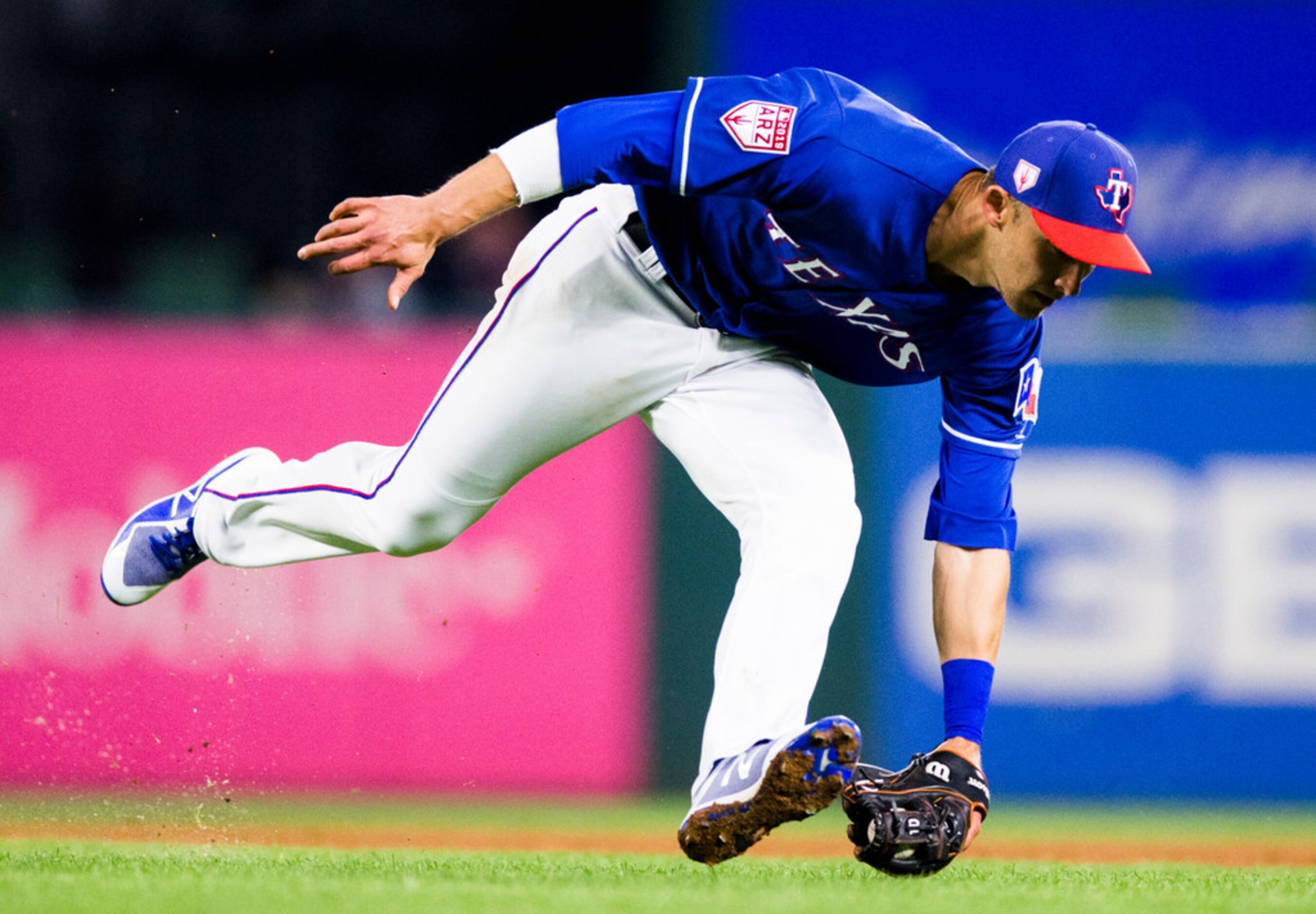 Texas Rangers fielder Eli White (80) fields a grounder during the seventh inning of a spring...