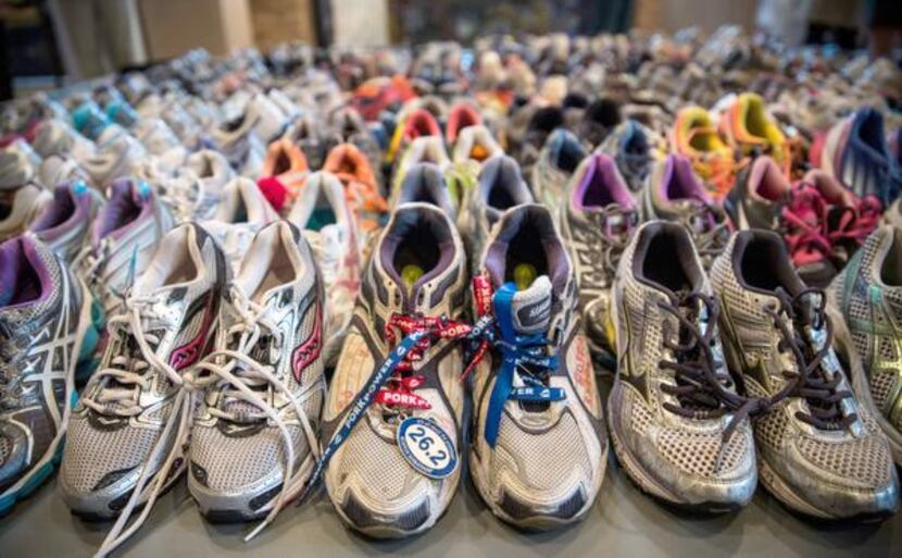 
Running shoes are laid out en masse at the Boston Public Library display. The surviving...