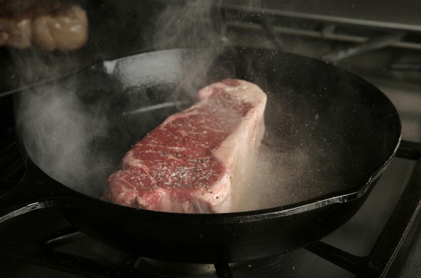 Searing a New York strip steak.