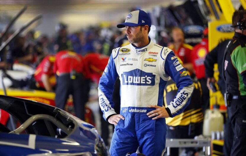 Sprint Cup Series driver Jimmie Johnson waits for adjustments to made to his car in the...