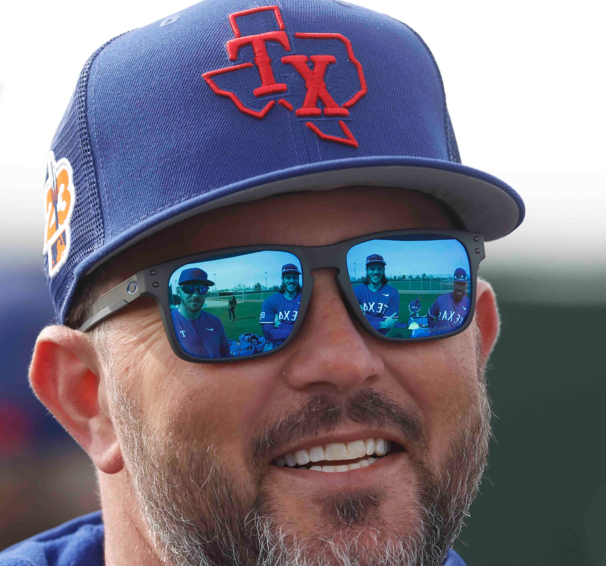 Texas Rangers catchers Mitch Garver, left, Jonah Heim, center, and Sandy Leon are reflected...