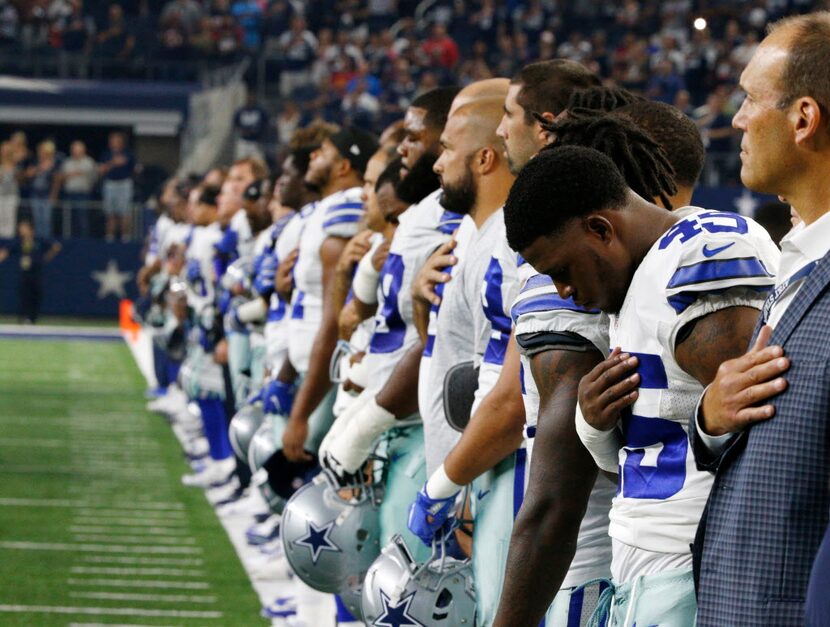 The Dallas Cowboys line up for the National Anthem before their game against the Houston...