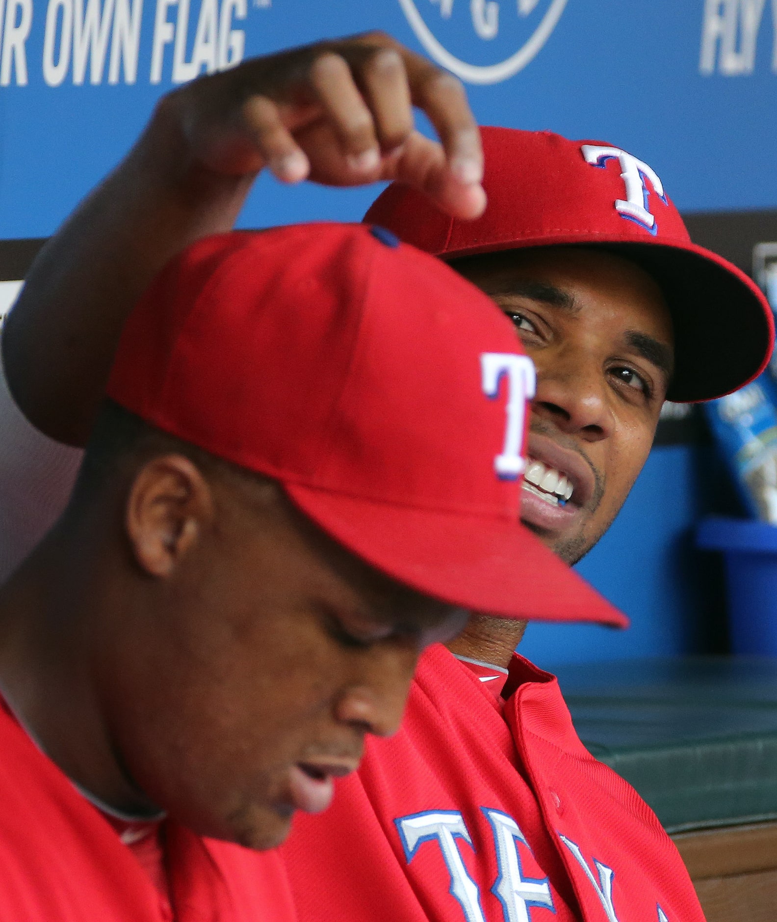 Texas shortstop Elvis Andrus playfully bothers teammate Adrian Beltre on the bench in the...