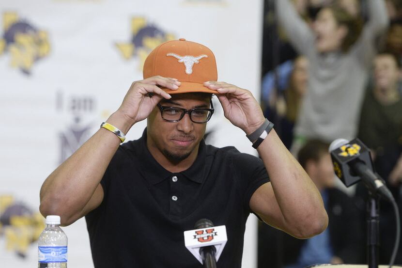 Nacogdoches High School football player Brandon Jones dons a UT cap as he announces that he...