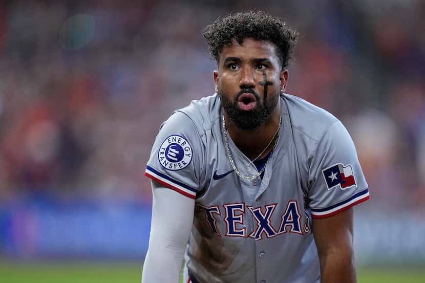 Texas Rangers' Ezequiel Duran reacts after being called out at first base on a double play...
