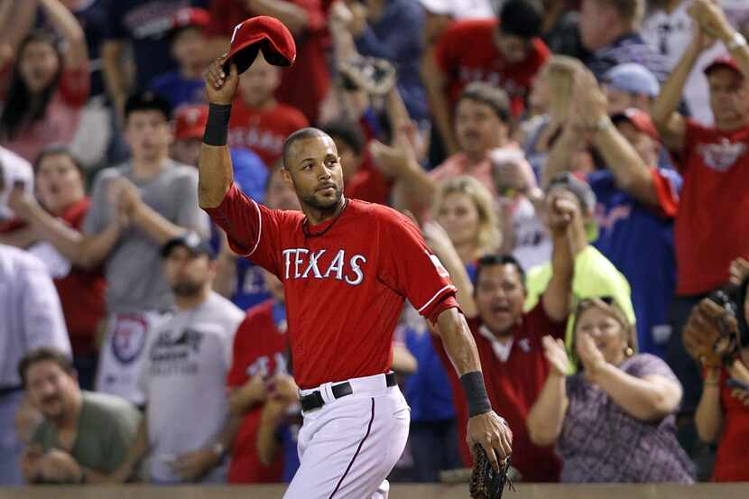 Texas Rangers right fielder Alex Rios (51) tips his hat to the crowd as the public address...