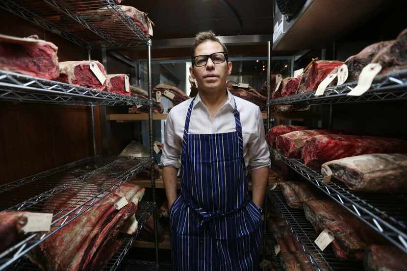 Chef John Tesar stands near dry-aged prime cuts in the meat locker at the Knife restaurant...