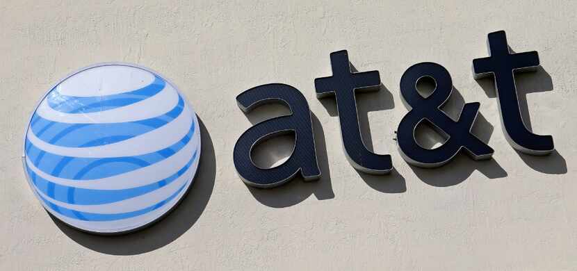 This Feb. 8, 2017, file photo shows the AT&T sign at a store in Hialeah, Fla. 