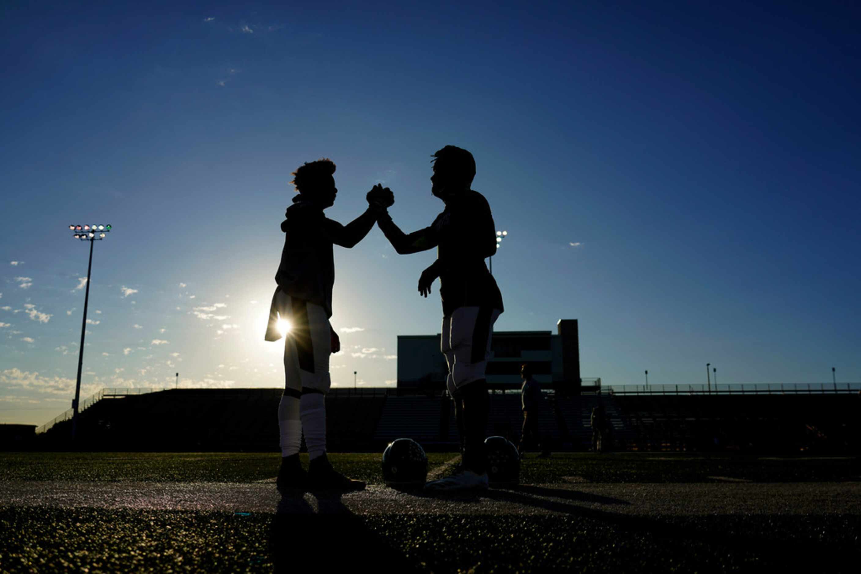 Arlington players warm up before a high school football game against the Arlington Bowie at...
