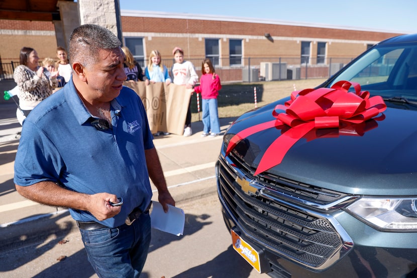 Custodian Lucino Perez walks to check out his new car at Amy Parks-Heath Elementary,...