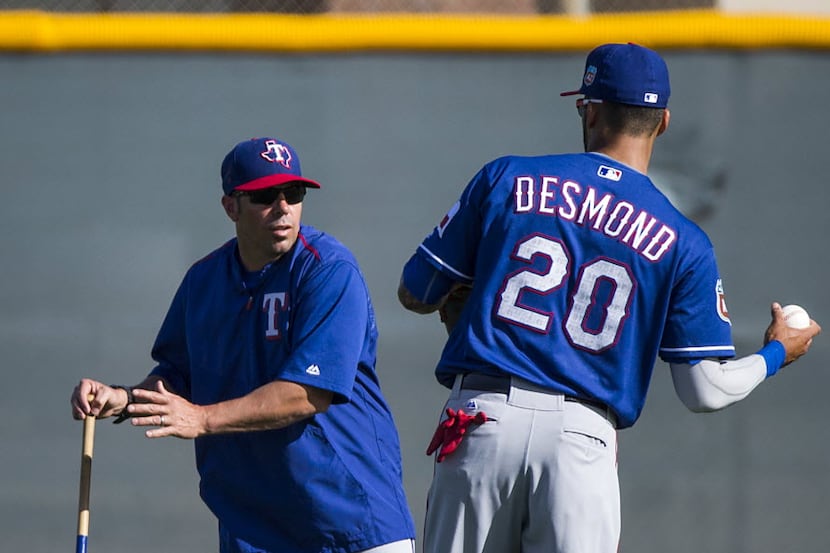Texas Rangers outfielder Ian Desmond works with field coordinator Jayce Tingler during a...