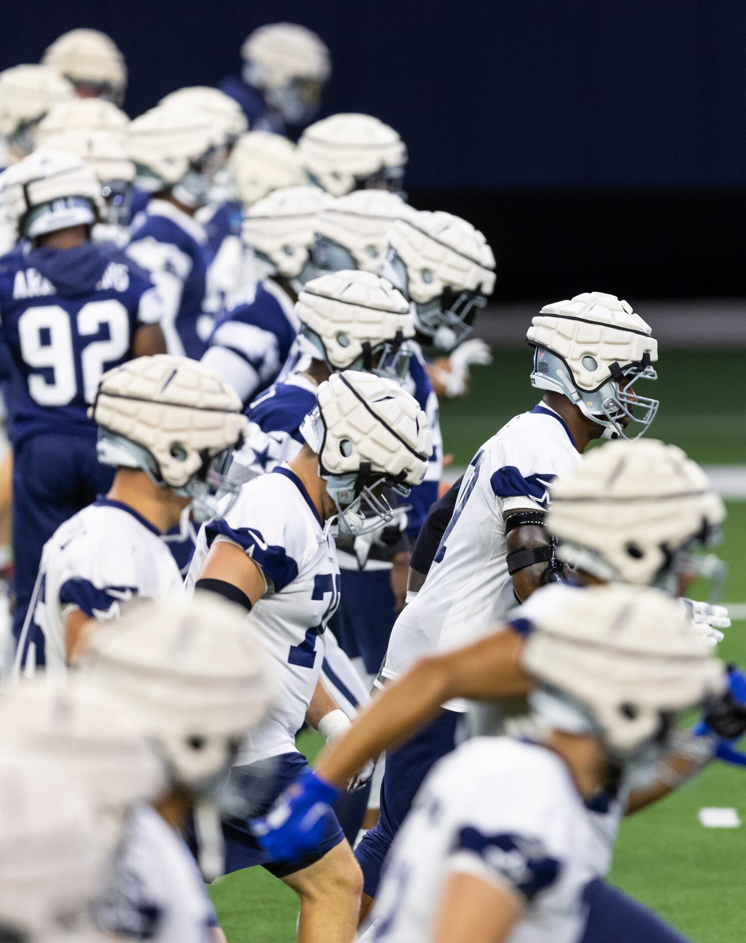 Dallas Cowboys players are seen wearing padded covers on top of their normal helmets during...