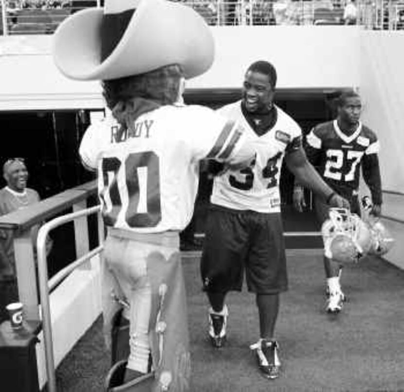 Cowboy Deon Anderson got stopped on his way to the field by team mascot Rowdy on Tuesday...