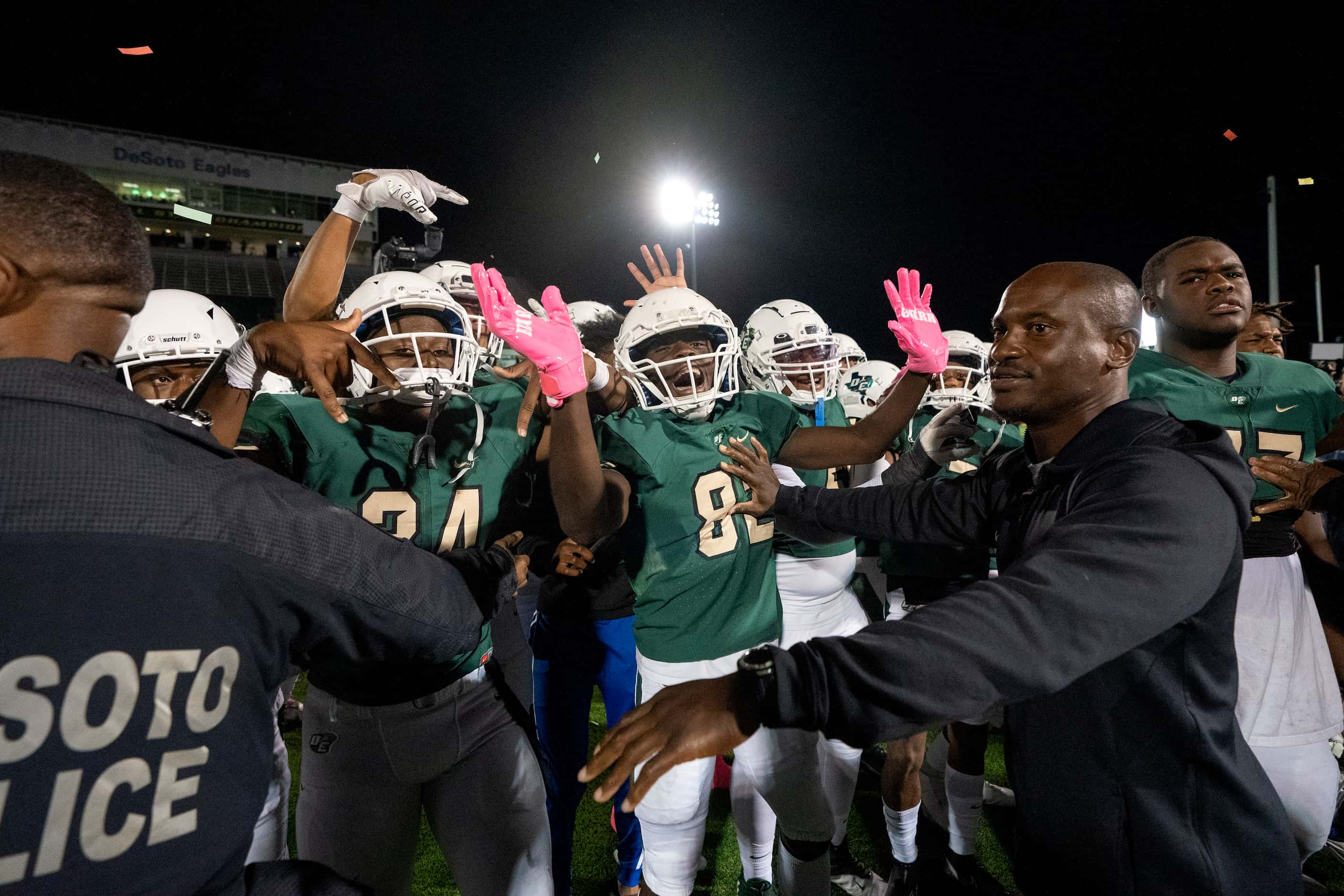 DeSoto coaches and police stand guard as DeSoto players wave goodbye to Cedar Hill players...