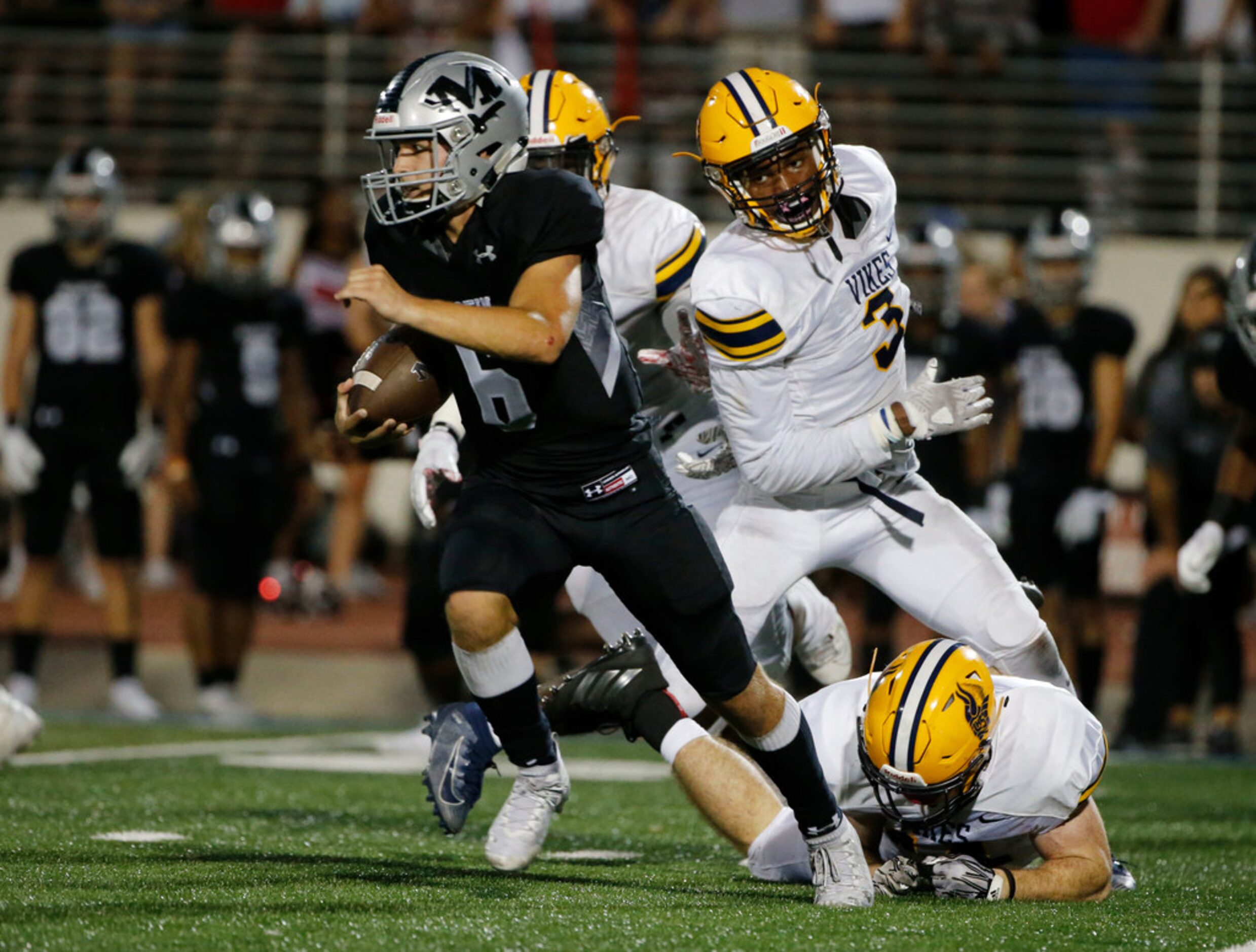 Arlington Martin quarterback Zach Mundell (6) runs away from Arlington Lamar defenders James...