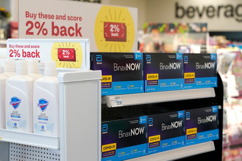 Boxes of home COVID-19 tests made are sold next to liquid hand soap at a CVS store in...