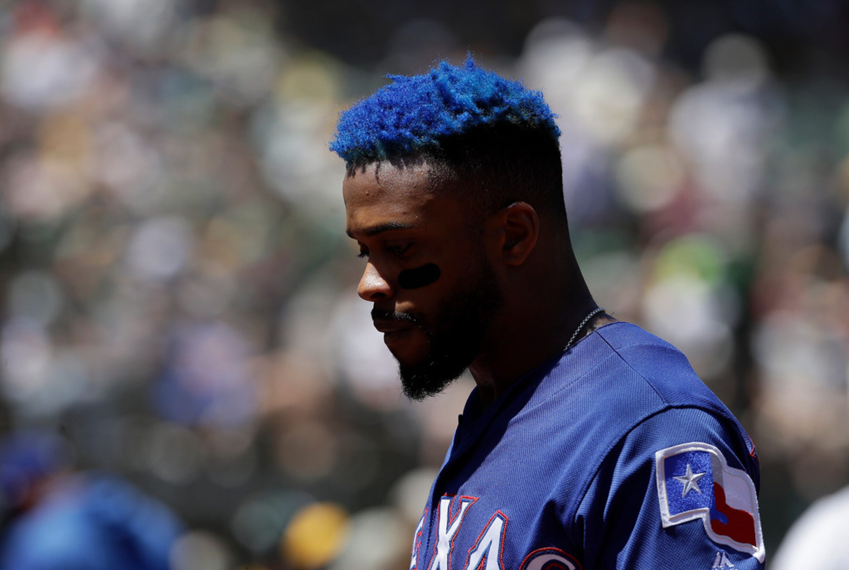 Texas Rangers' Delino DeShields walks to the dugout during the second inning of a baseball...