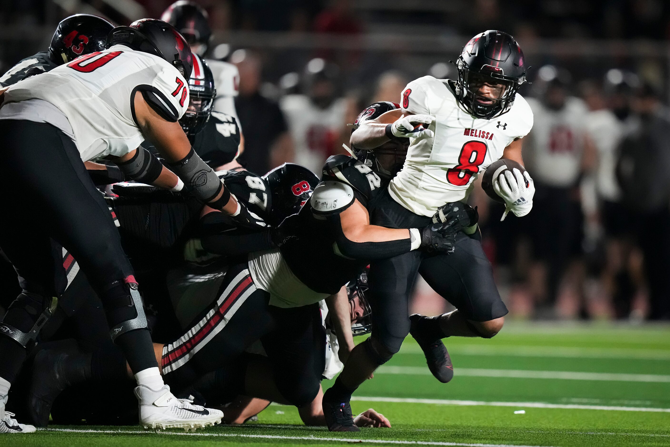 Melissa’s Jacob Fields (8) is brought down by Lovejoy defensive lineman Nick Perez (82)...