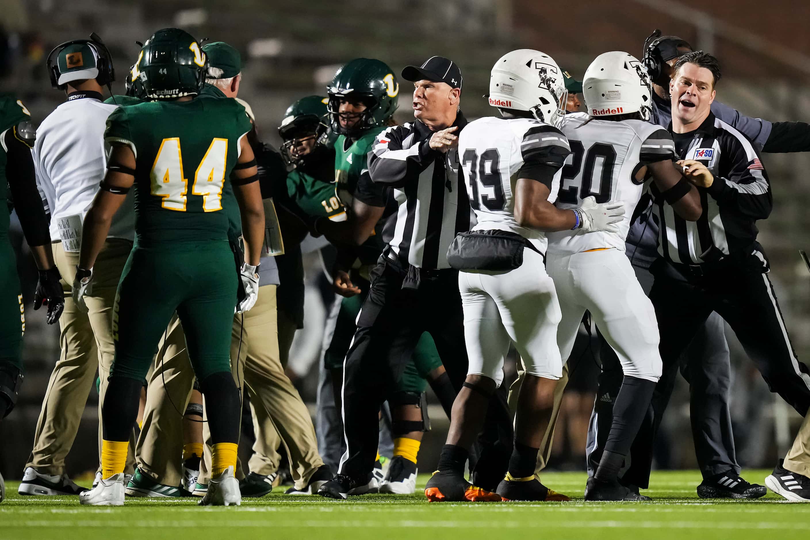 Officials try to separate players including Longview tight end Angel Ramos and Mansfield...