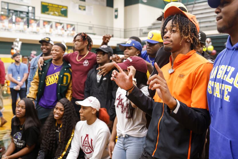 DeSoto wide receiver Stephon Johnson, right, gestures a Oklahoma State symbol during a photo...