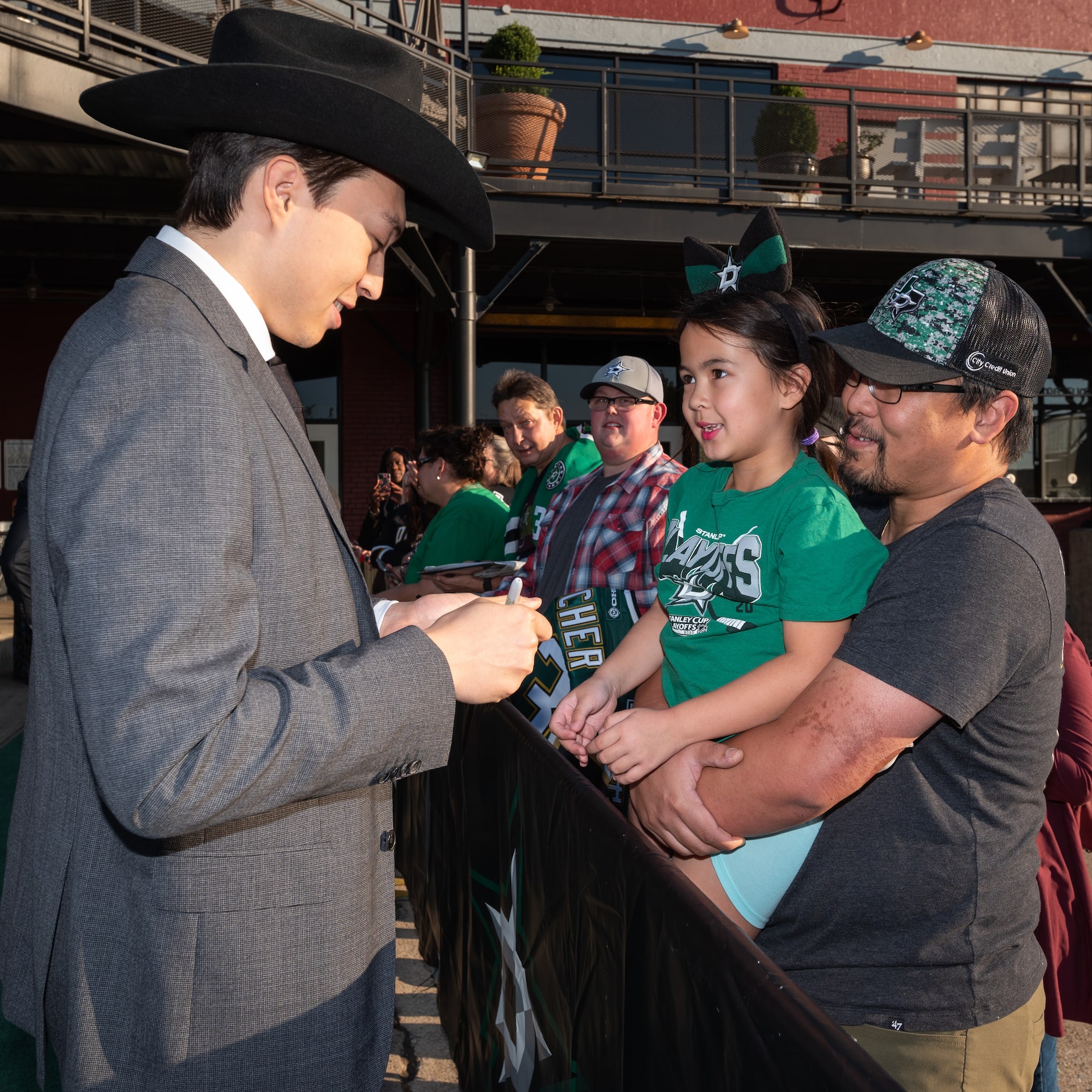 Dallas Stars player Jason Robertson, left, signs his autograph while meeting fans Rosalyn...