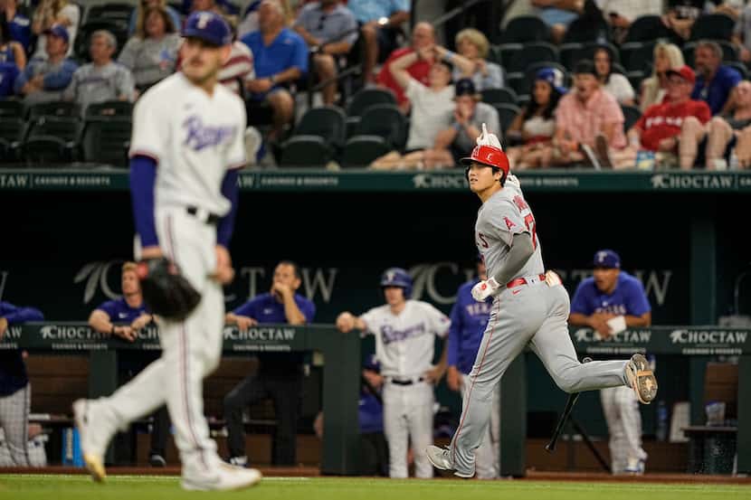 Los Angeles Angels' Shohei Ohtani, right, runs the bases after hitting a two-run home run...