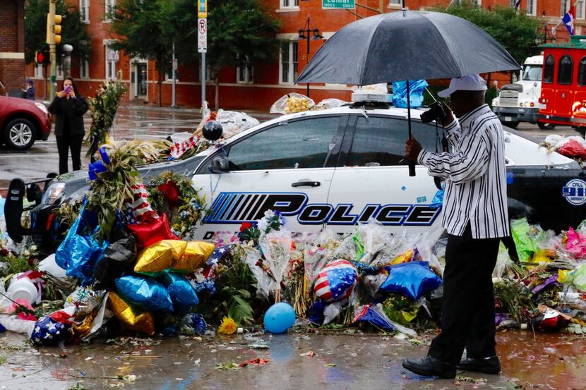 Thomas Freeney of Dallas took photos of the memorial at Dallas police headquarters in the...