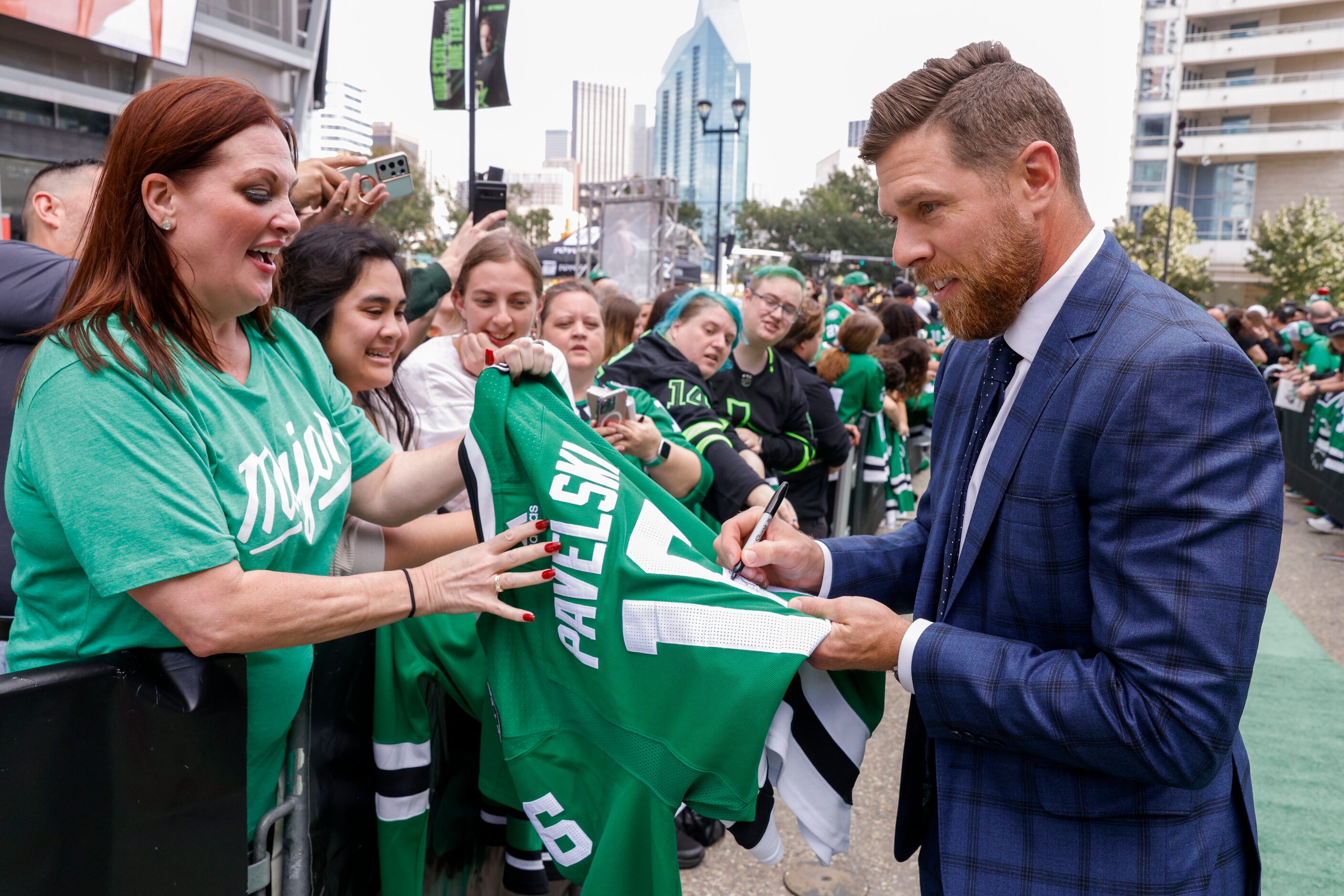 Dallas Stars center Joe Pavelski signs a jersey for Hannah Luna of Argyle on the green...