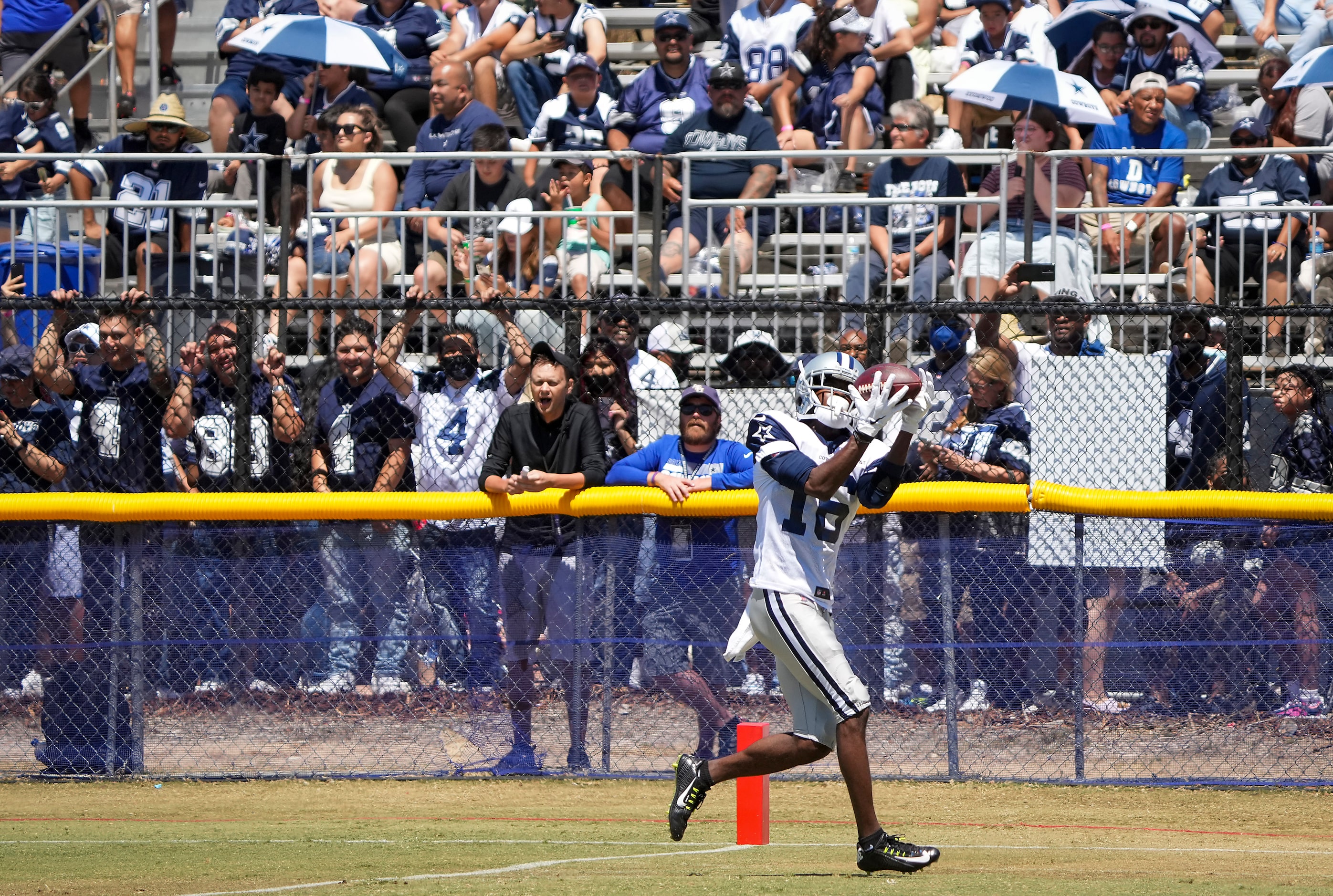 Dallas Cowboys fans watch wide receiver Reggie Davis haul in a pass during a practice at...