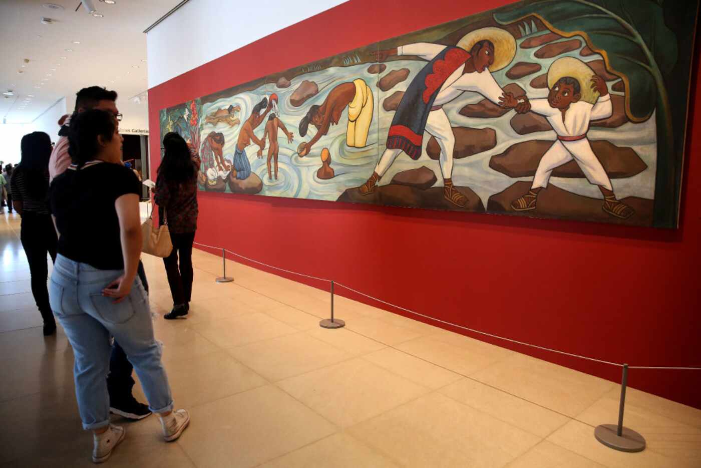 Rebecca Nava and Anthony Sierra (far left) look at "Juchitan River" by Diego Rivera in the...