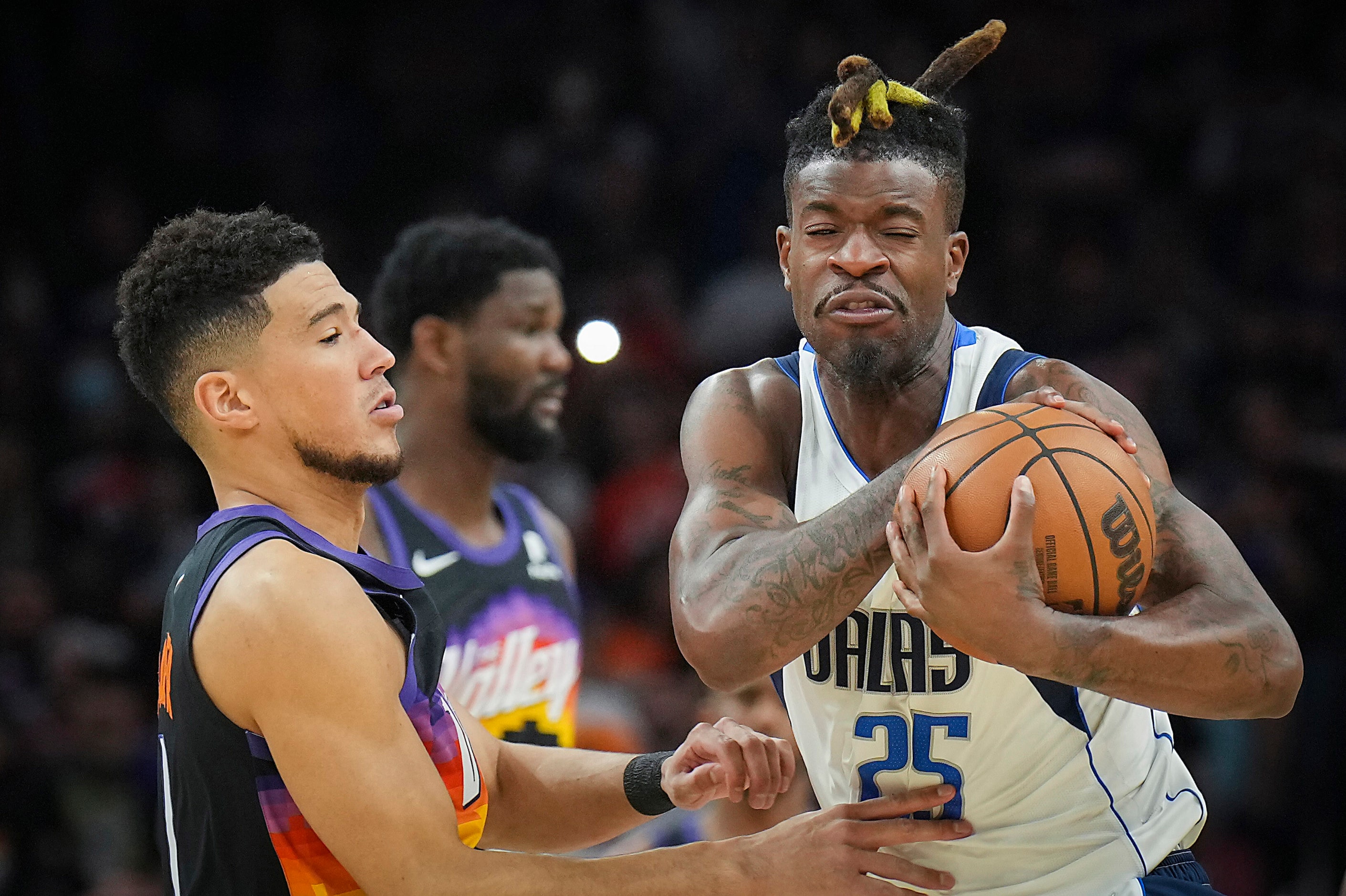 Dallas Mavericks forward Reggie Bullock (25) wrestles a ball away from Phoenix Suns guard...