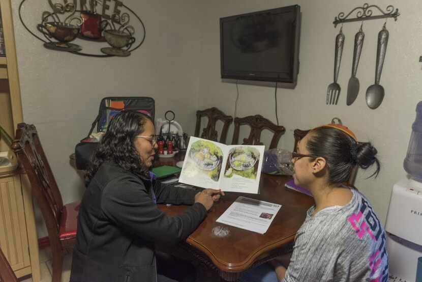 María Rodríguez (der.) recibe instrucción del programa HIPPY que le ayuda a enseñar a su...