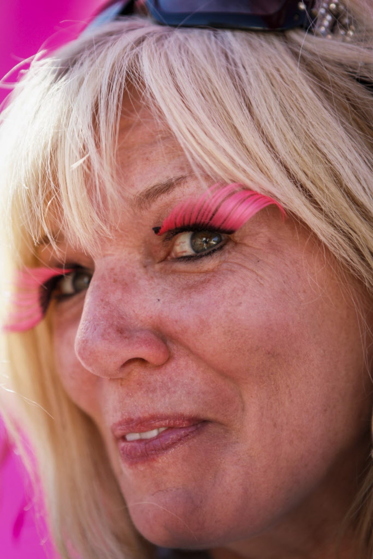 Event volunteer Donna Edwards sports pink eyelashes while waiting to congratulate people at...