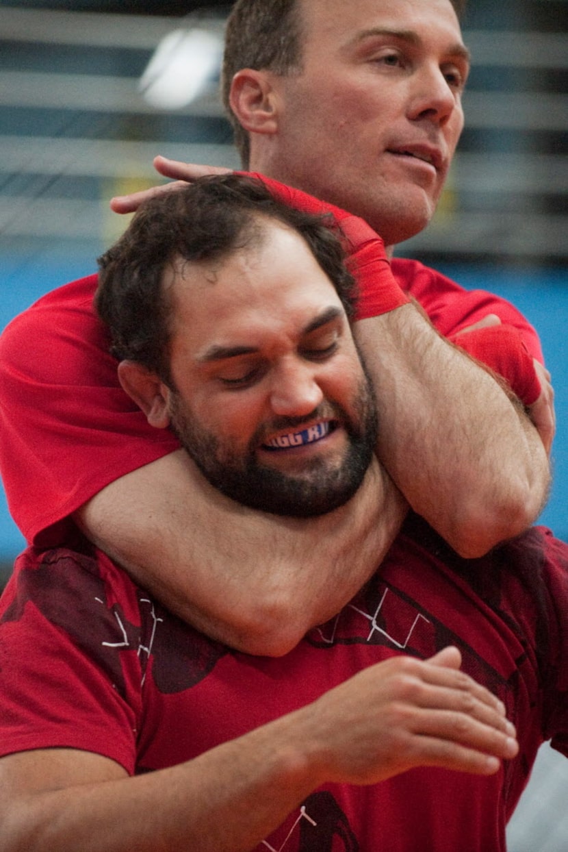 NASCAR driver Kevin Harvick (top) puts MMA fighter Johny Hendricks (bottom) in a choke hold...