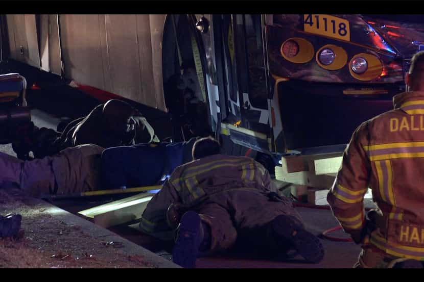 Dallas firefighters worked to remove an injured man from beneath a DART bus early Wednesday...