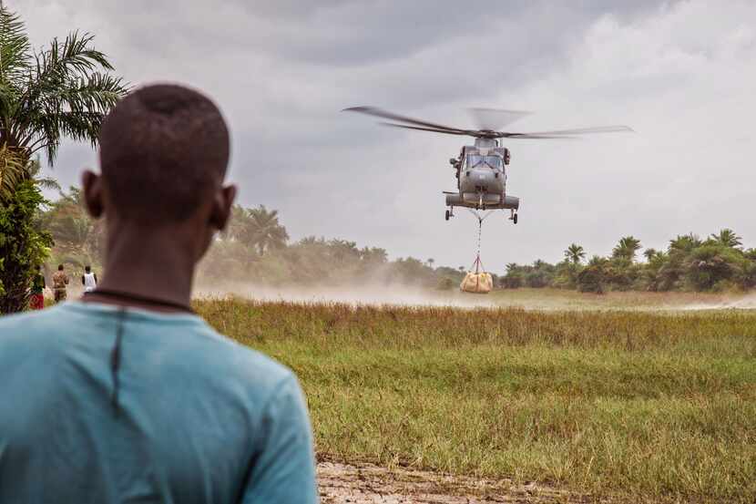 A local resident awaited the landing of a British Navy helicopter as it dropped food aid on...