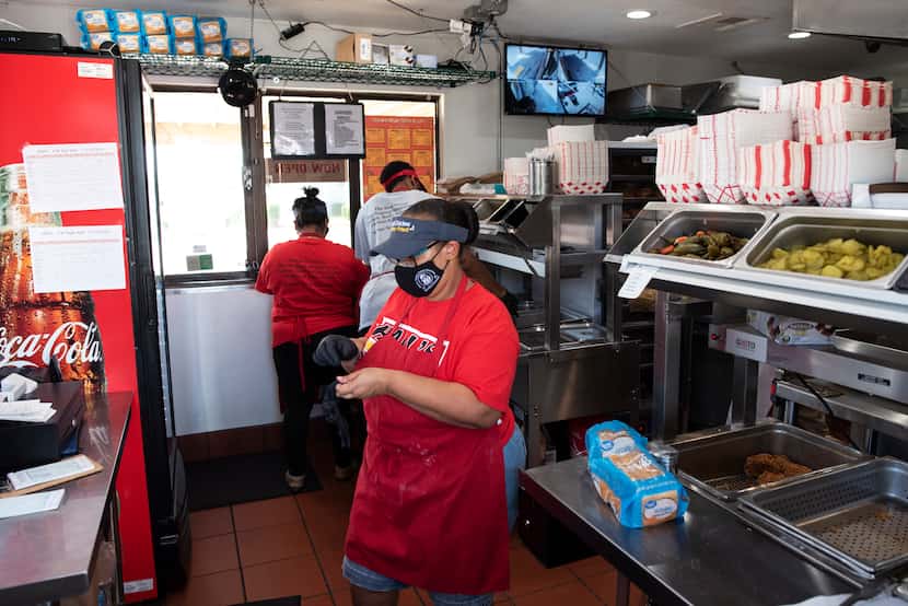 Employees prepare food orders inside the reopened Hall's Honey Fried Chicken on West Camp...