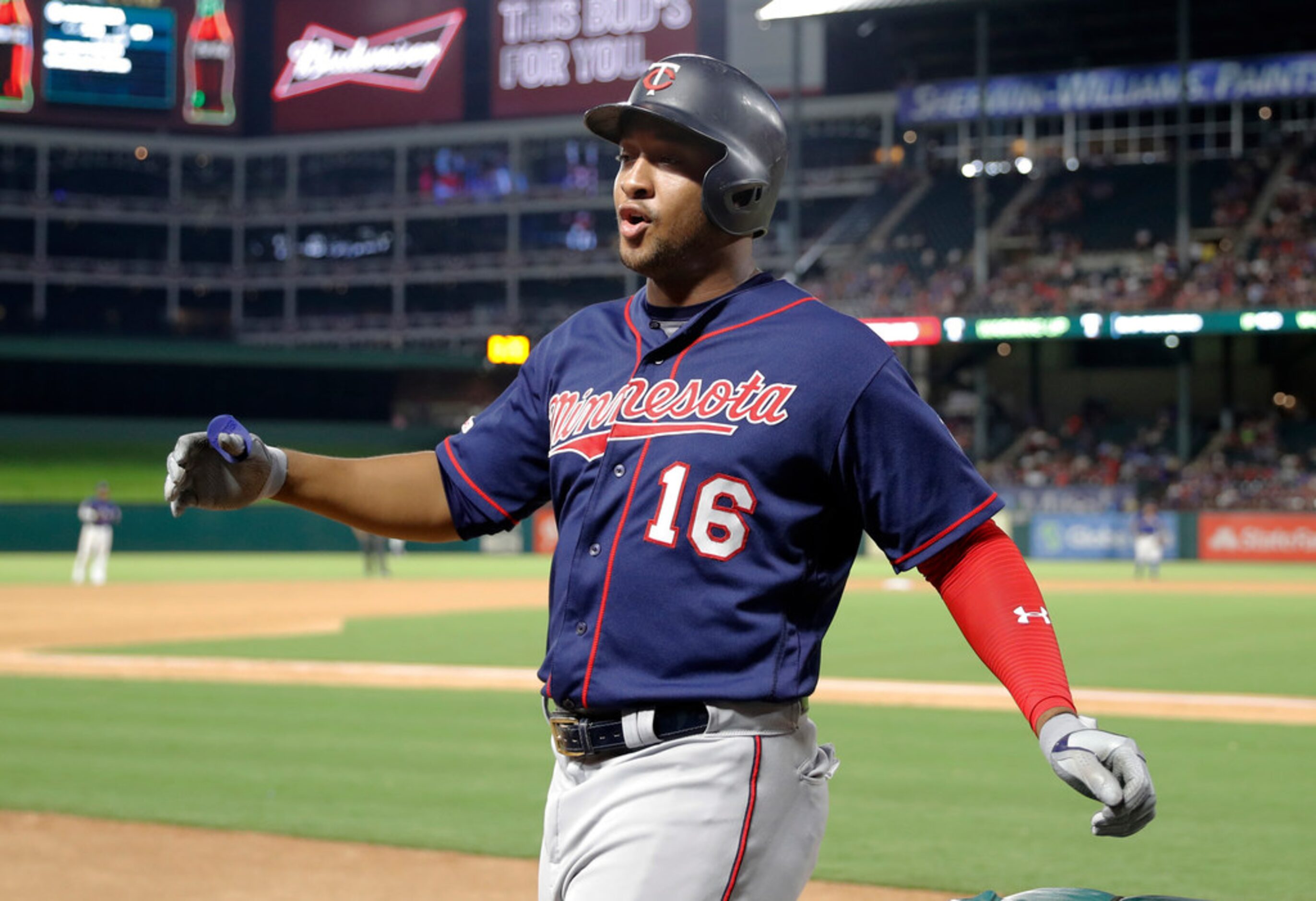 Minnesota Twins' Jonathan Schoop celebrates as he walks up to the dugout after hitting a...