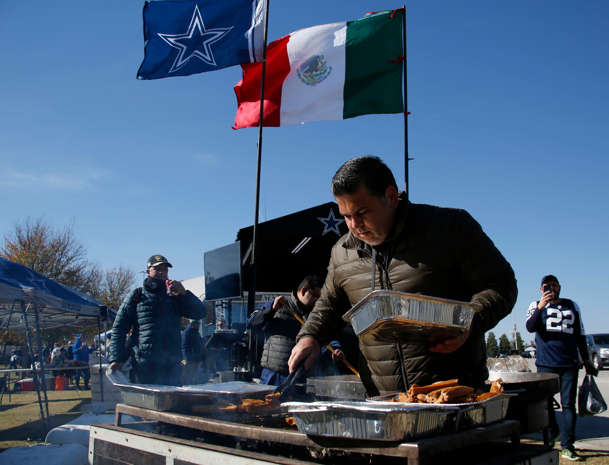 Javier Serna prepares tamales during a tailgating party. Serna was among 50 fans that made...
