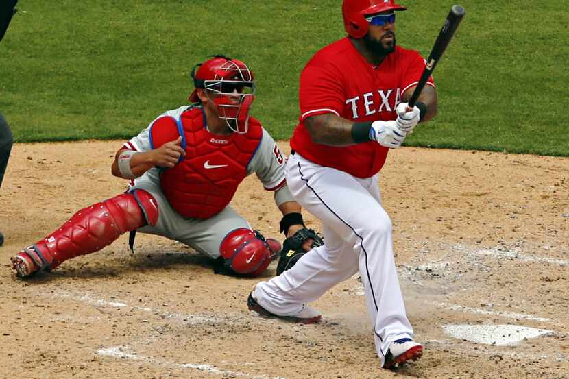 Philadelphia Phillies catcher Carlos Ruiz (left) looks on as Texas Rangers first baseman...
