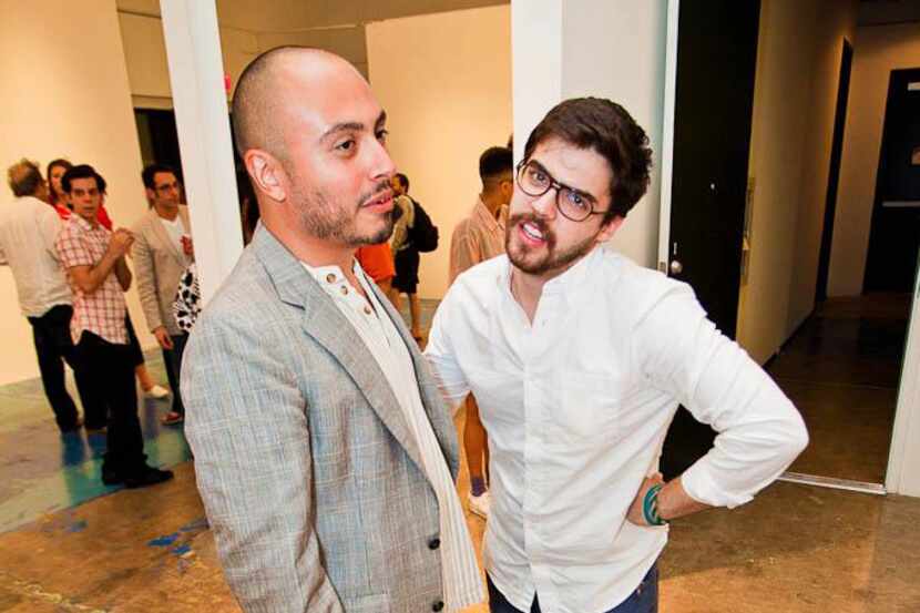 Arthur Peña and Kevin Rubén Jacobs talk at a gallery exhibit. 
