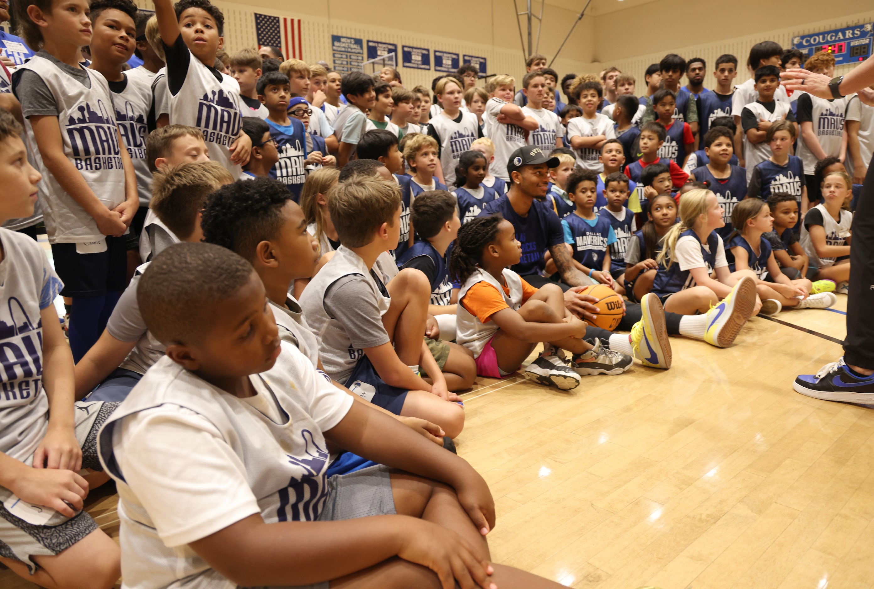 Dallas Mavericks forward and center PJ Washington, center right, is surrounded by Hoop Camp...