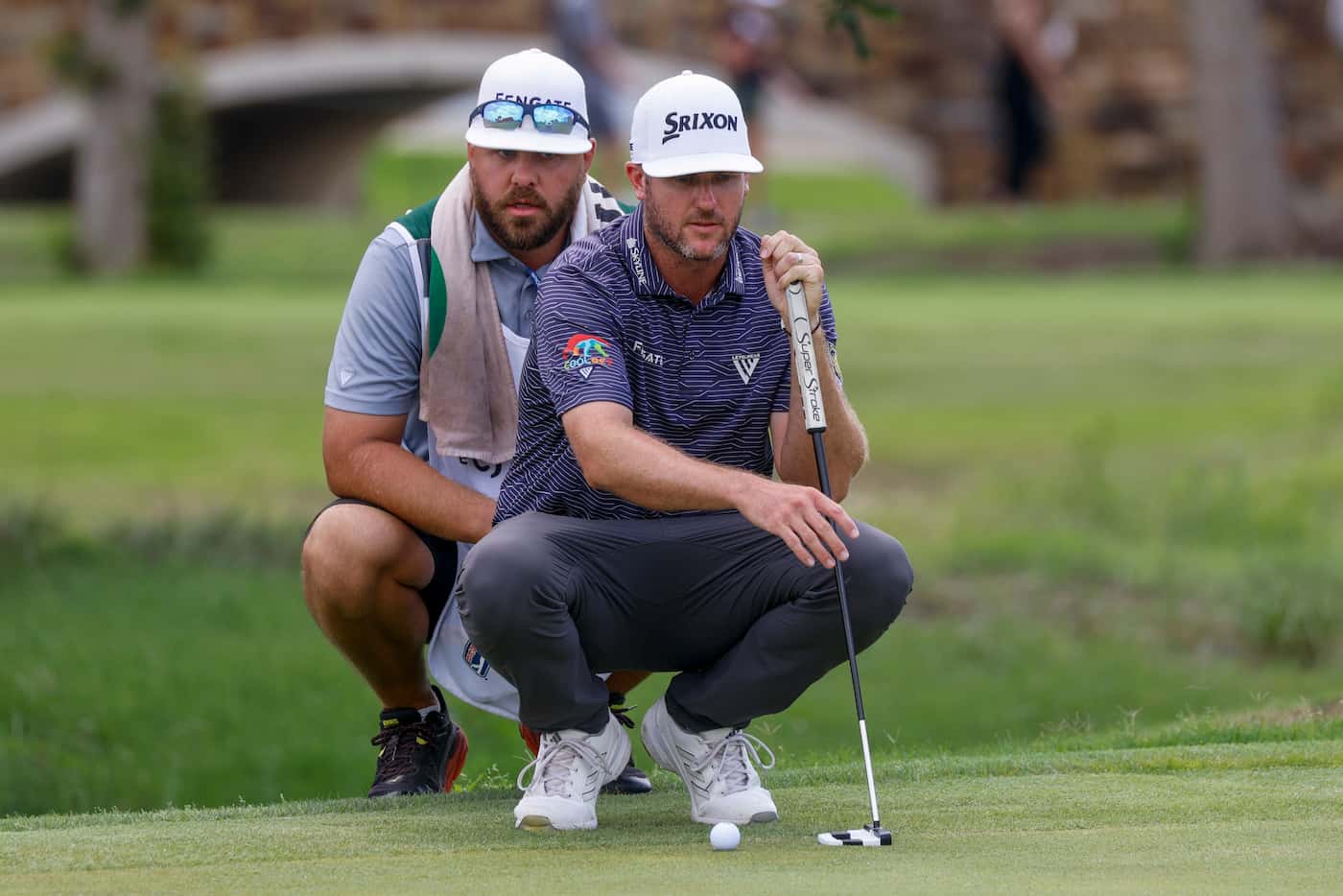 Taylor Pendrith lines up his putt with his caddie Mitchell Theoret on the 7th green during...